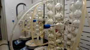 Lab scientist running large molecule analytical testing equipment in a biopharmaceutical testing lab
